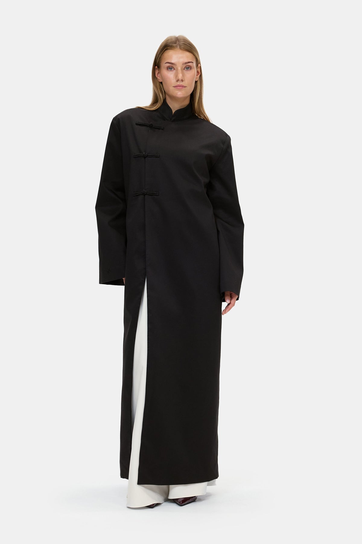 The Asymmetric Long Coat in Black, three quarter view
