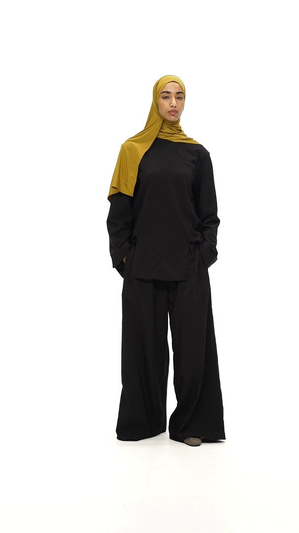Model walks in wearing the Structured Top and Structured Trousers in black